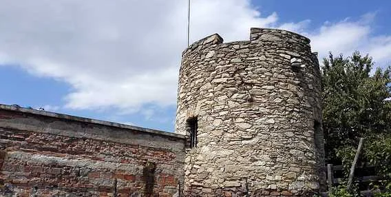 Znojemská kamenná věž s cihlovou zdí na pozadí oblohy.